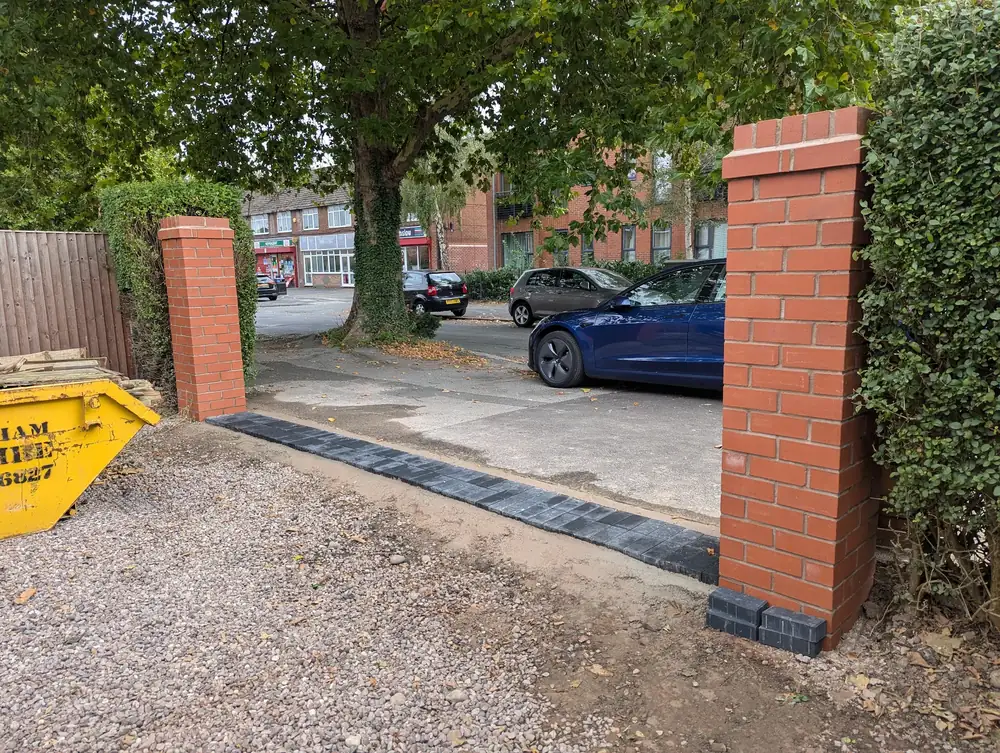 Red brick driveway pillars with a block paved threshold, built by AJ Brickwork in Manchester