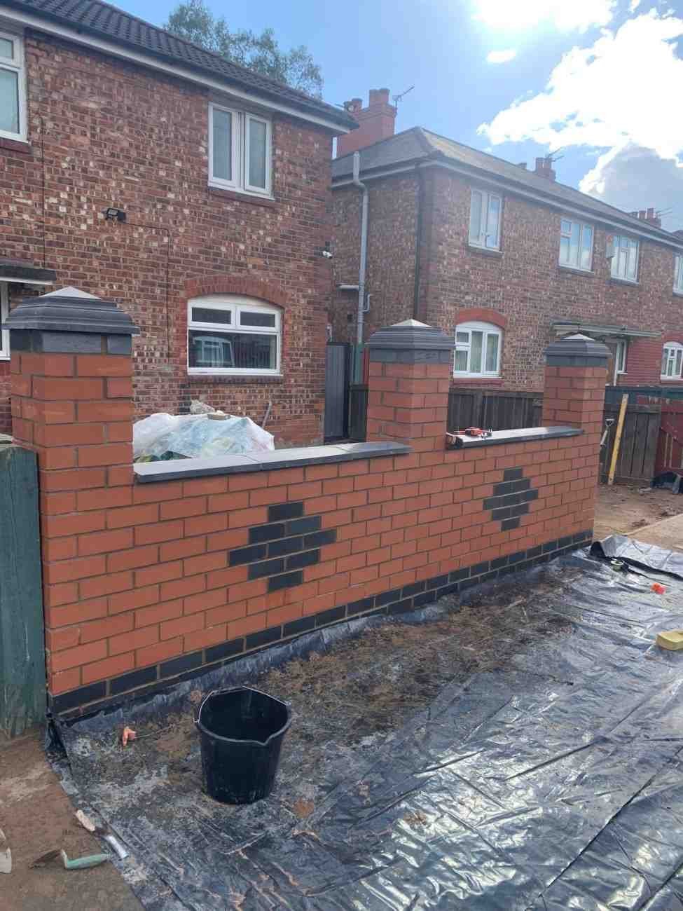 Red brick wall with dark feature brick detail and piers, built by AJ Brickwork in Manchester