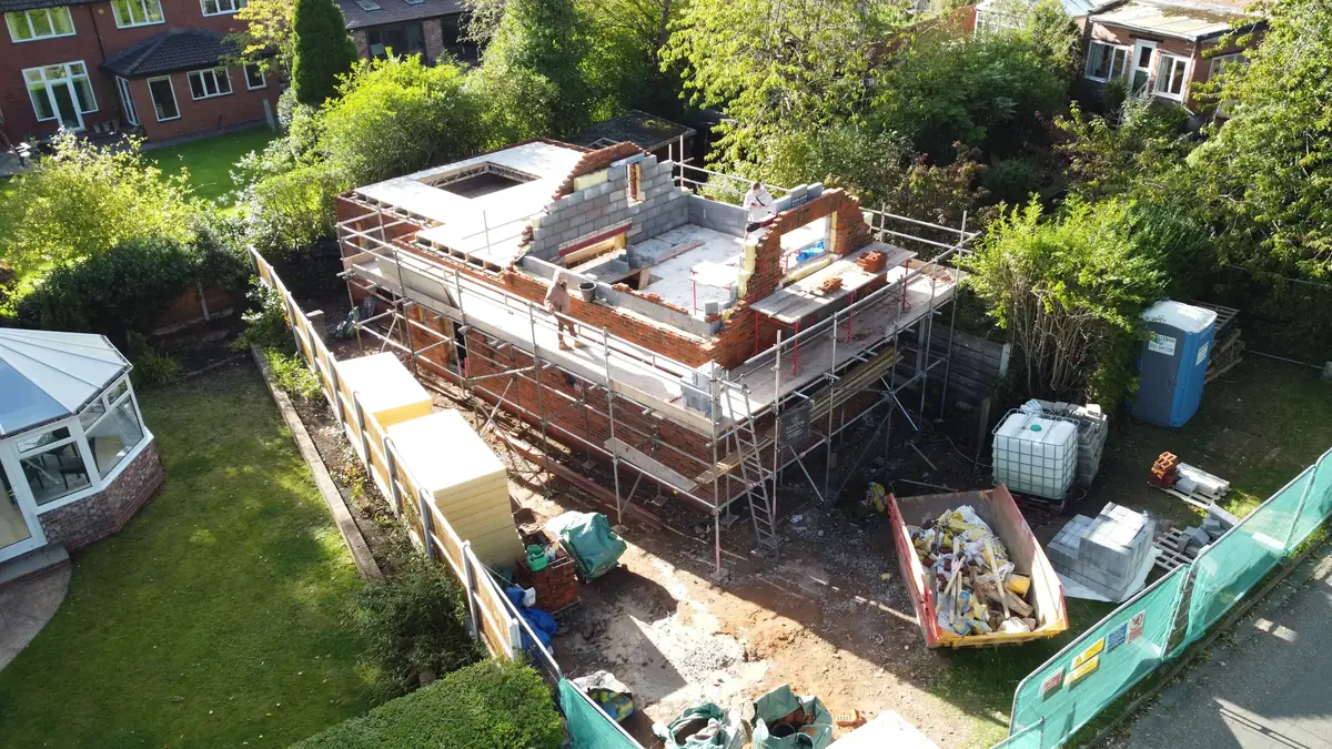 Two storey extension under construction in brick and block with scaffolding, seen from above